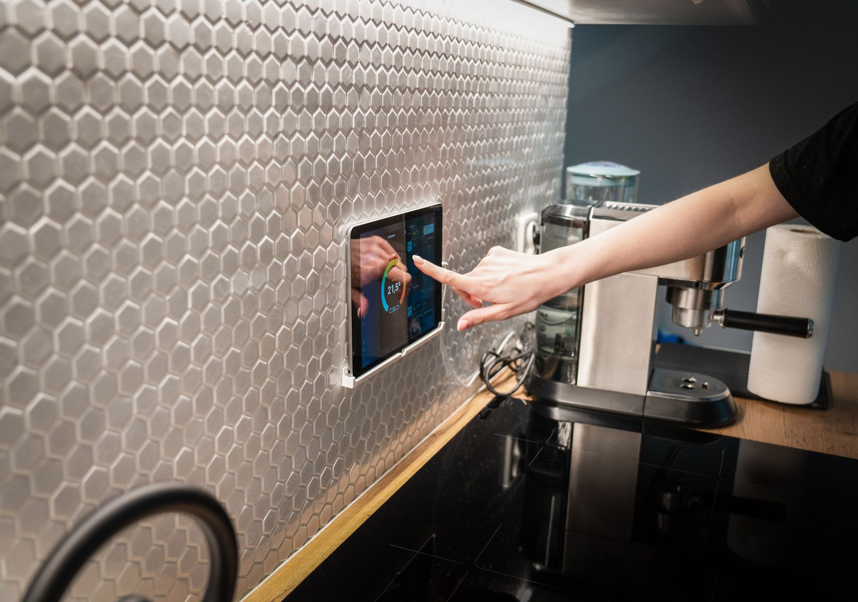 Resident using a wall-mounted smart-home control touchscreen